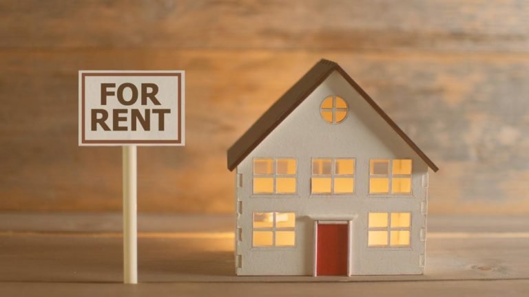 house figurine with a for rent sign next to it