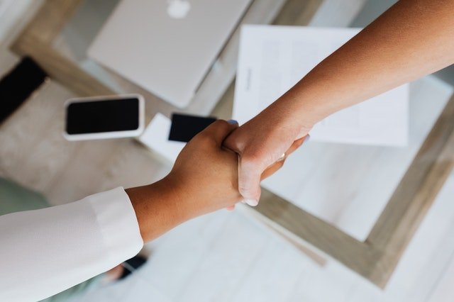 two people shaking hands over a document